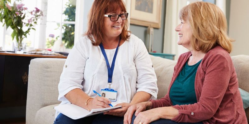 senior support worker talking to a female patient