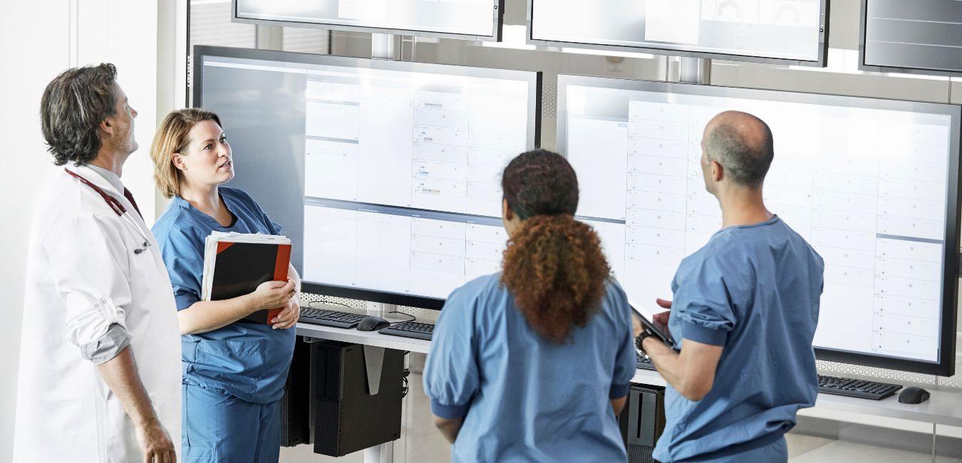 Healthcare workers around digital screens
