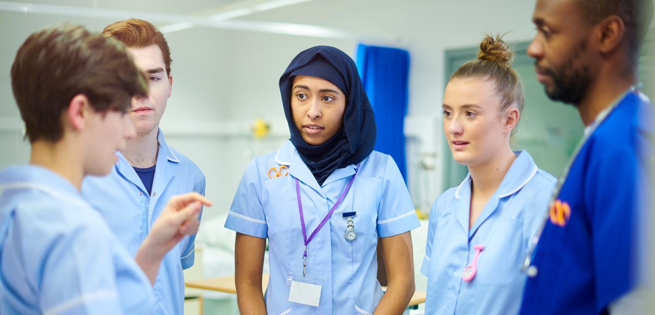 5 nurses in conversation at hospital